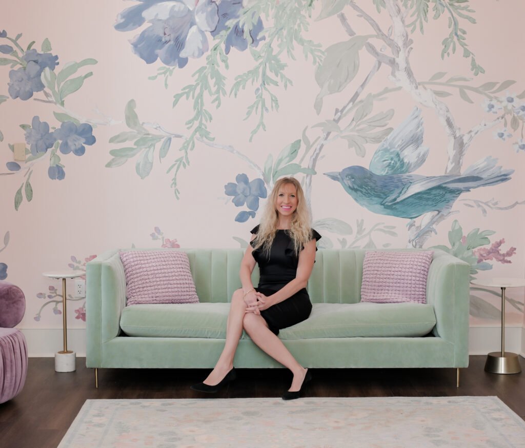 Elle Rudisill sitting on a sage couch